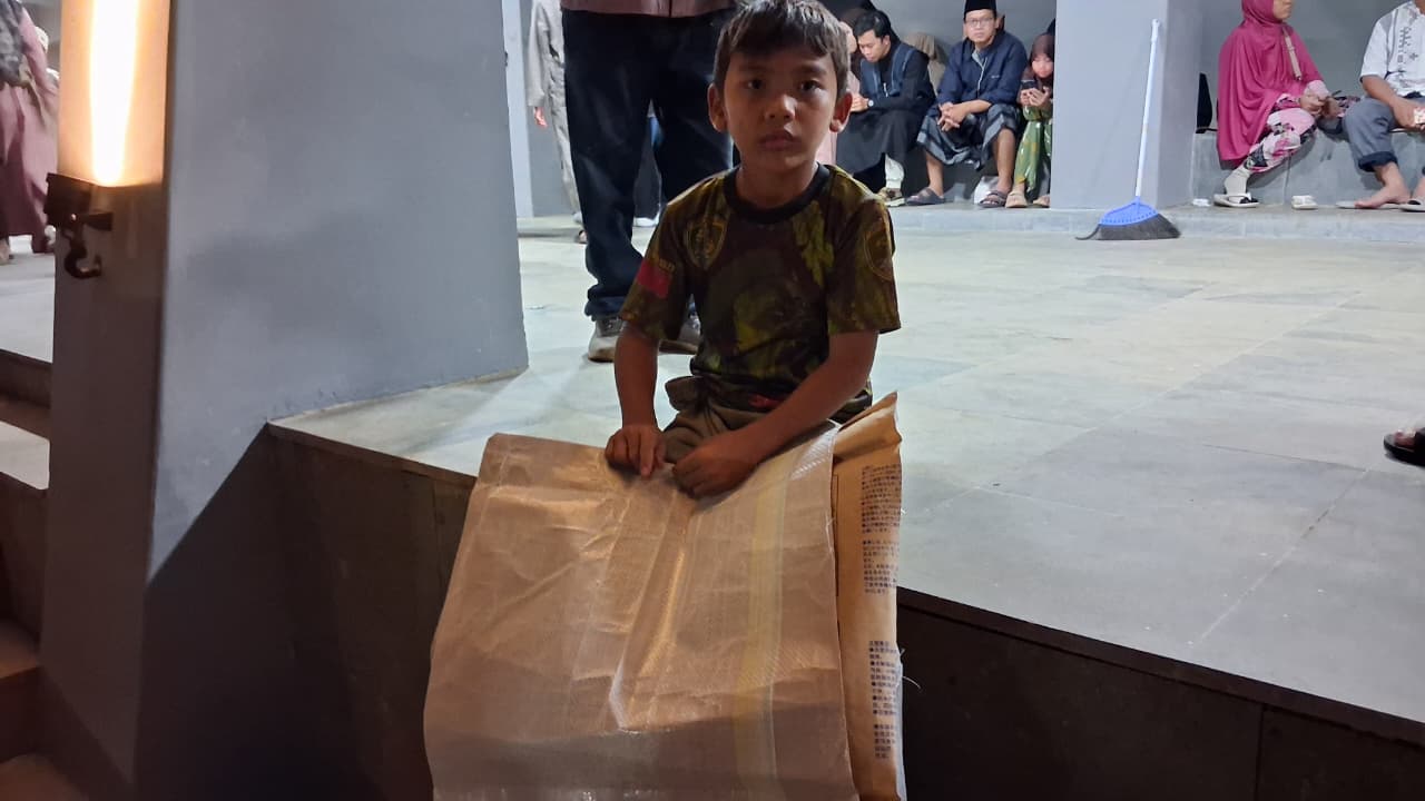 Shakel Radiansyah Bana, berusia 9 tahun menyewakan alas duduk di tengah keramaian acara Bupati Bogor.
