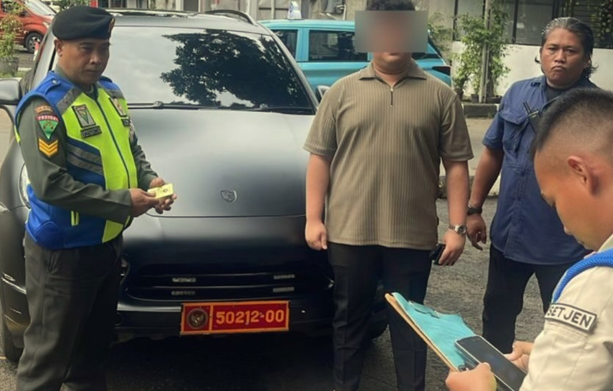 Petugas mendata mobil mewah Porsche Cayenne yang menggunakan pelat nomor dinas&nbsp;di kawasan Bandara Halim Perdanakusuma.