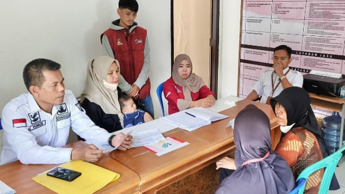 Ilustrasi petugas menyalurkan bansos kepada keluarga miskin penerima manfaat.