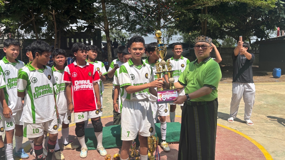 Penyerahan piala dan uang pembinaan kepada juara pertama oleh kepala sekolah.