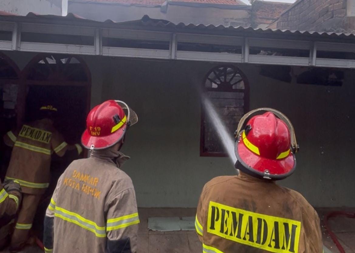 Petugas Damkar Kota Depok, saat memadamkan api yang membakar salah satu rumah di Pancoran Mas.