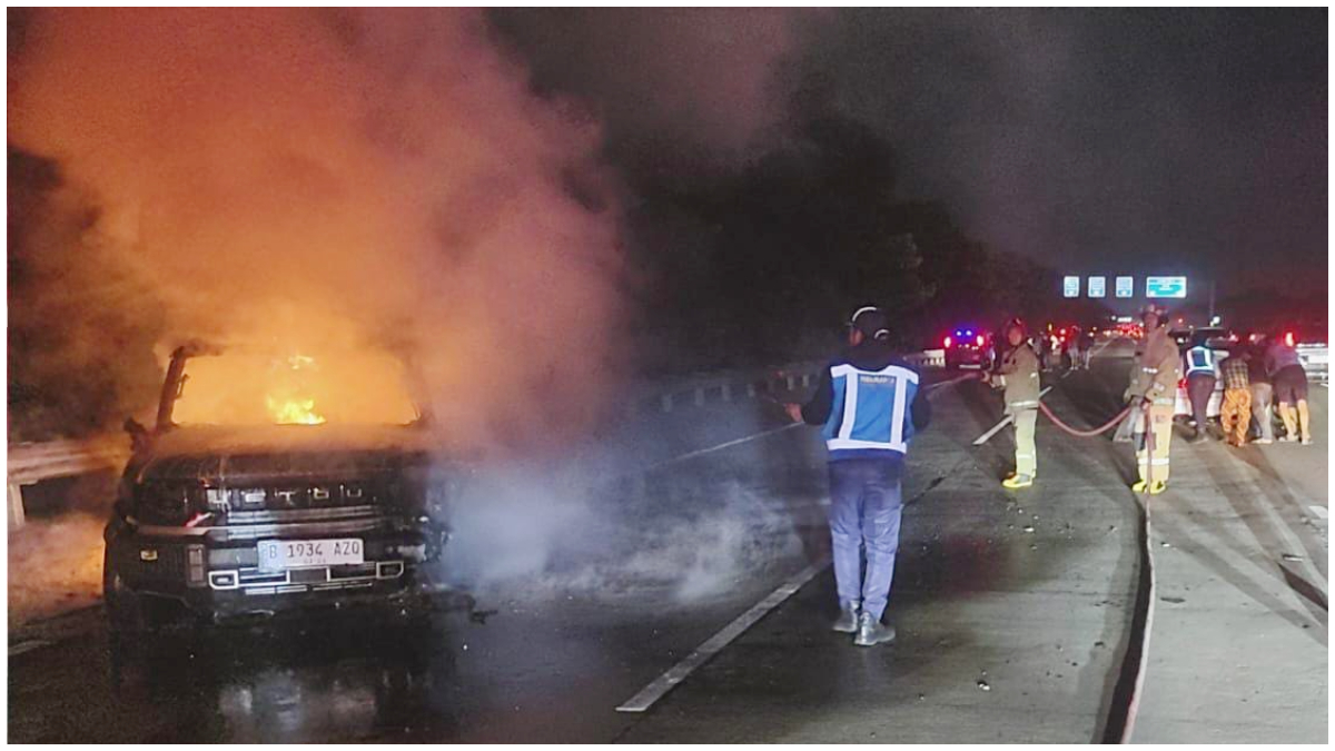 Petugas Damkar saat memadamkan satu unit mobil terbakar di Jalan Tol Jagorawi.