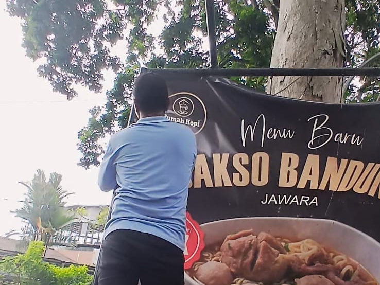 Petugas gabungan kecamatan dan kelurahan saat melakukan penertiban spanduk dan papan iklan tidak berizin di sepanjang Jalan Ahmad Yani.