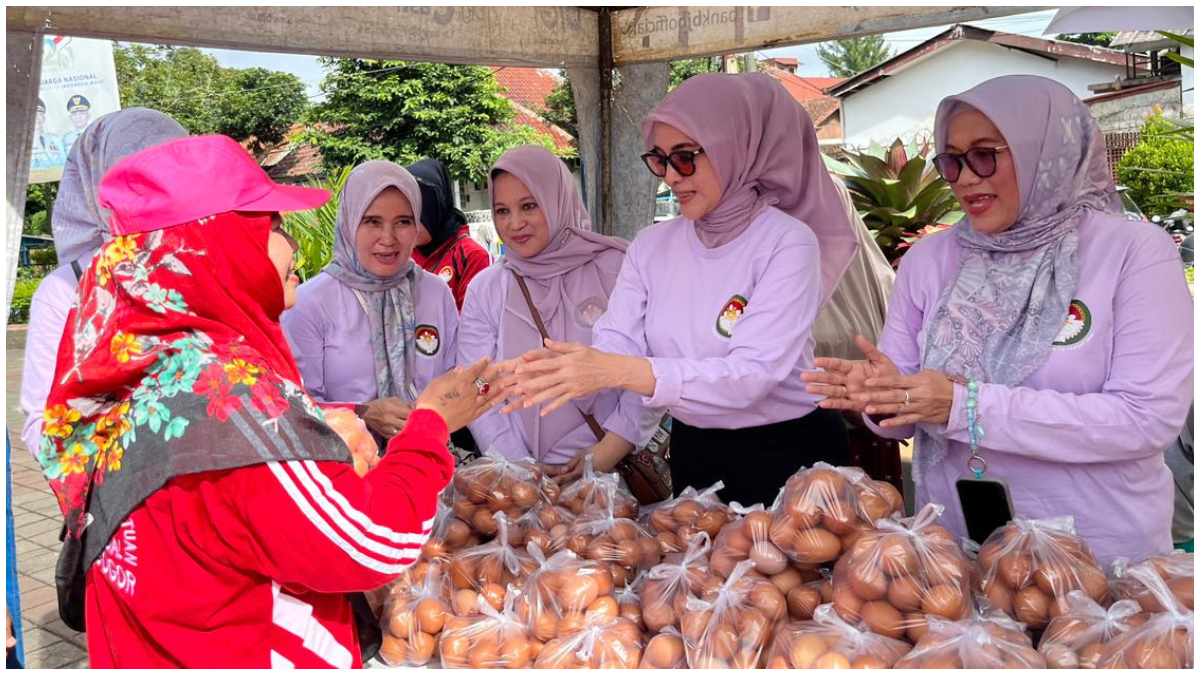 Penasihat DPW Kota Bogor Yantie Rachim didampingi Ketua DWP Kota Bogor, Dewi Sondari Denny Mulyadi saat menyerahkan sembako murah kepada warga pada kegiatan bazar.