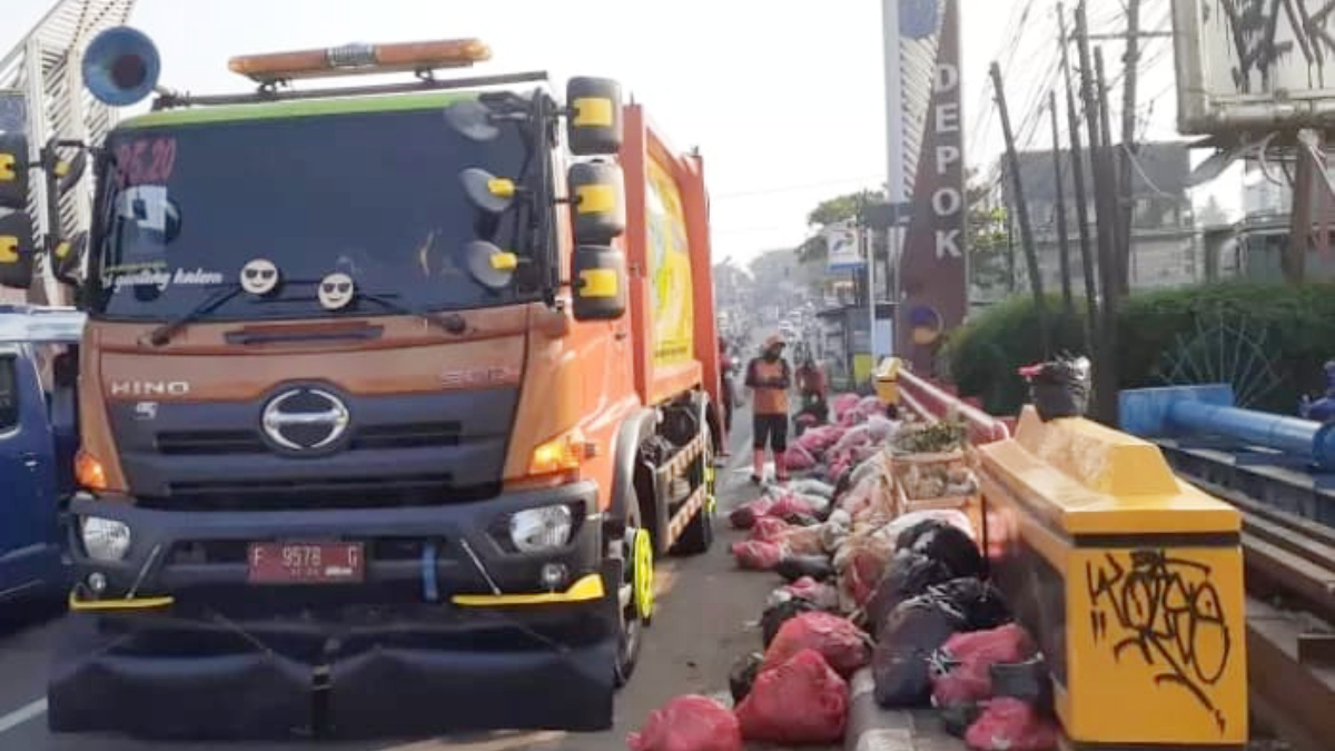 Petugas saat mengangkut sampah menggunakan armada truk compactor di wilayah Parung, Kabupaten Bogor.