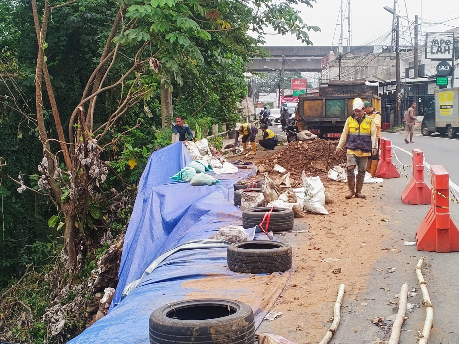 Pekerja melakukan pengerjaan longsor di Jalan Raya Kebon Pedes, Kecamatan Tanah Sareal, Kota Bogor.