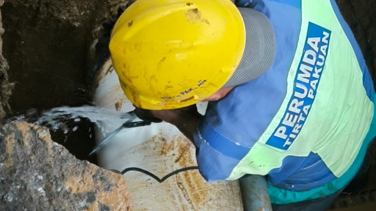 Petugas Perumda Tirta Pakuan Kota Bogor menangani kebocoran pipa transmisi di jalur Tangkil menuju wilayah Caringin.