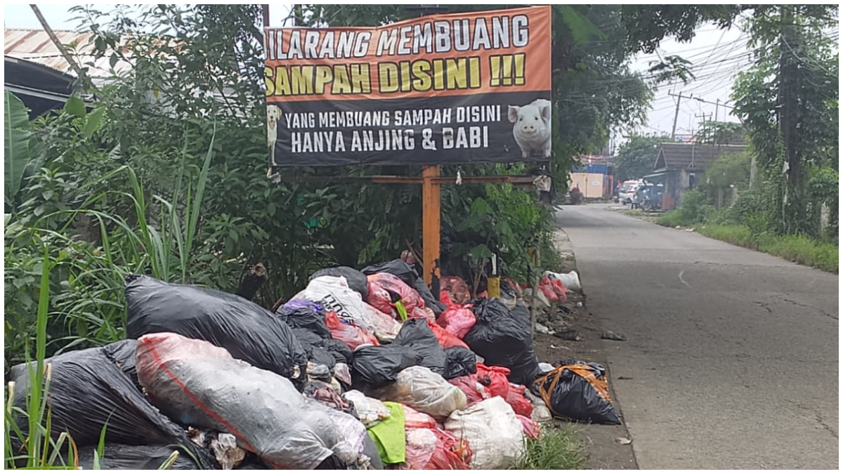 Warga pasang spanduk bergambar anjing dan babi di Jalan Raya Tapos yang kerap jadi tempat pembuangan sampah liar.
