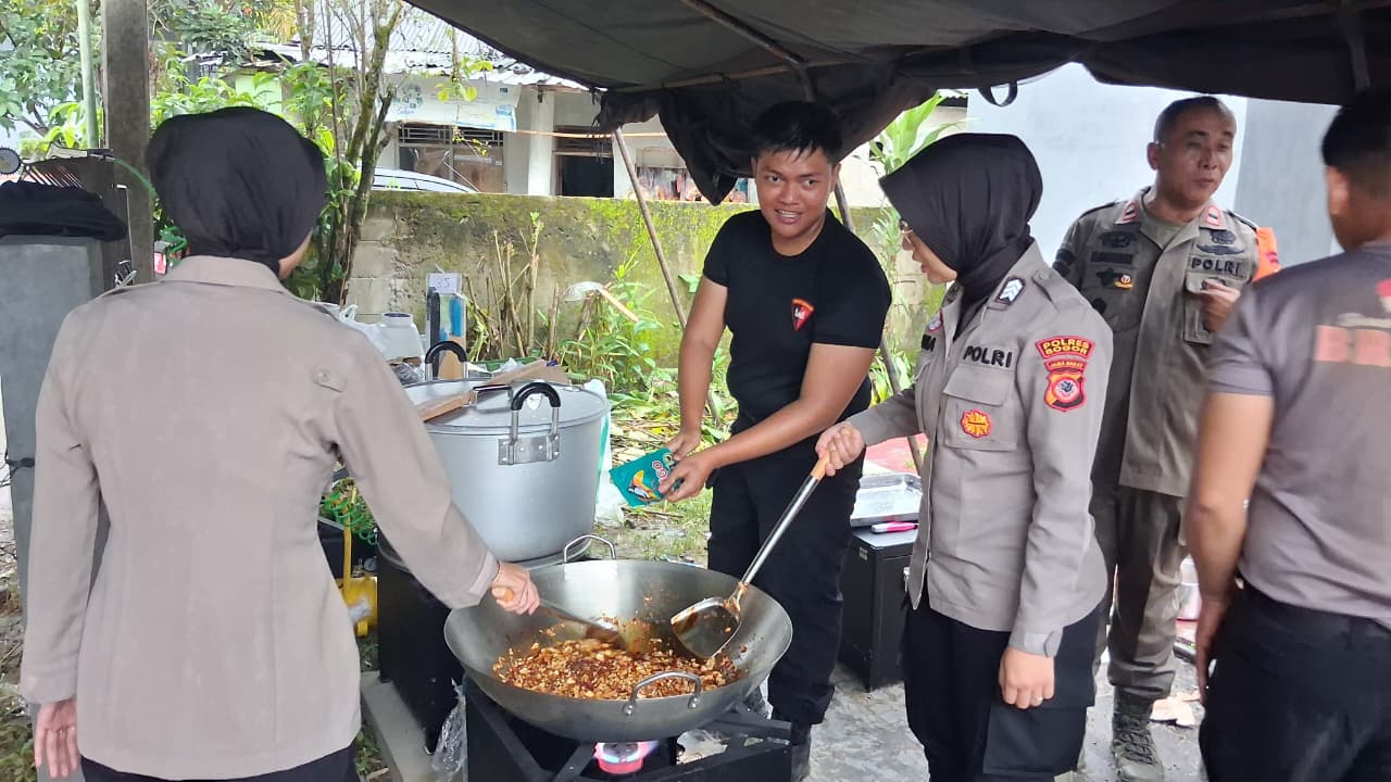 Aparat gabungan kepolisian saat memasak di dapur umum bencana banjir, Desa Cijayanti, Kecamatan Babakan Madang, Kabupaten Bogor, Kamis 12 Februari 2026.