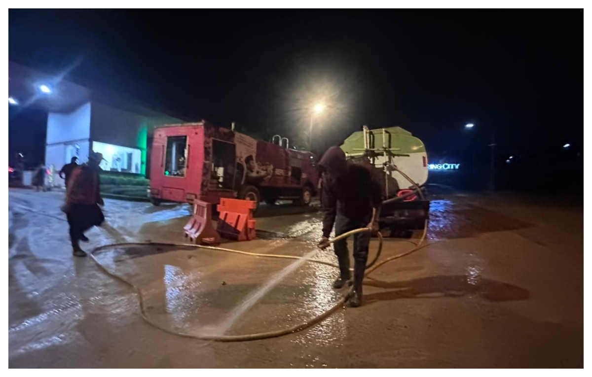Pihak Perumahan Sentul City, Kecamatan Babakan Madang, Kabupaten Bogor, membersihkan jalan yang sempat diterjang banjir, Rabu 11 Februari 2026 sore.