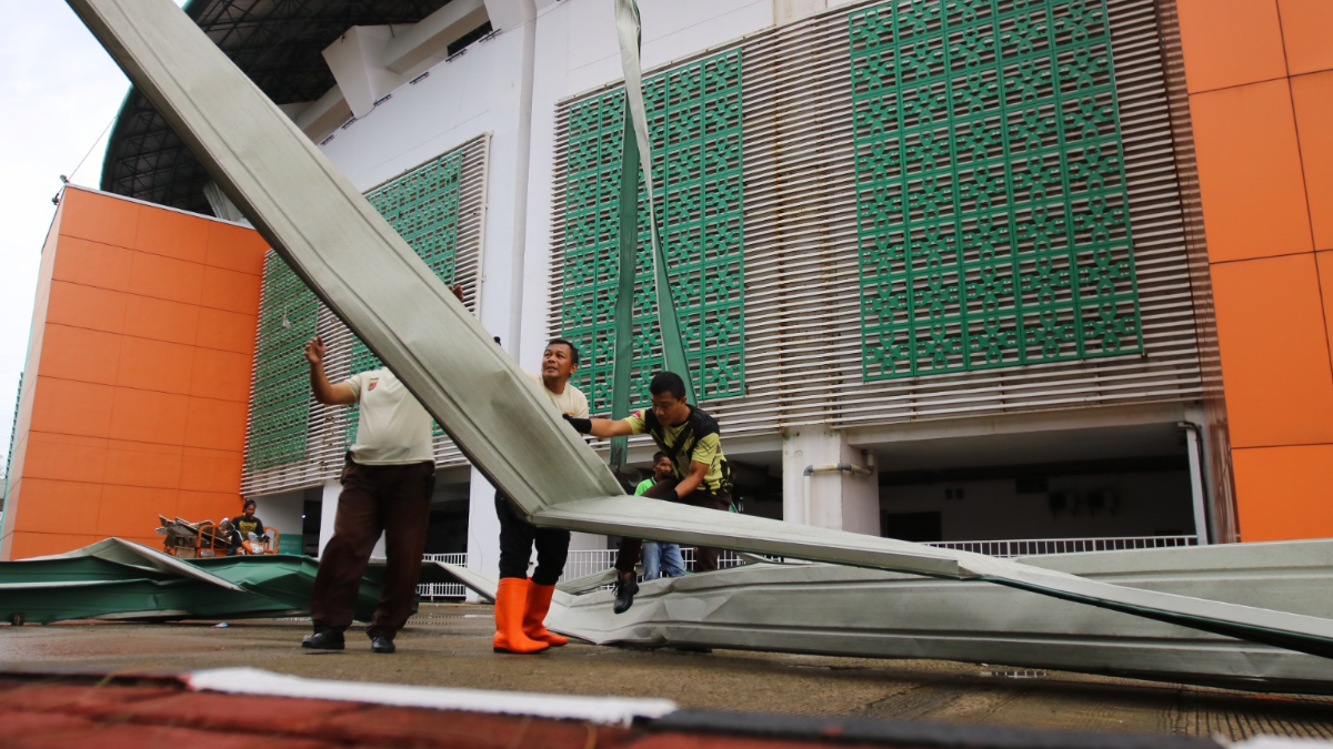 Petugas merapikan atap Gelora Pakansari yang roboh akibat angin dan hujan deras Kamis, 12 Februari 2026.