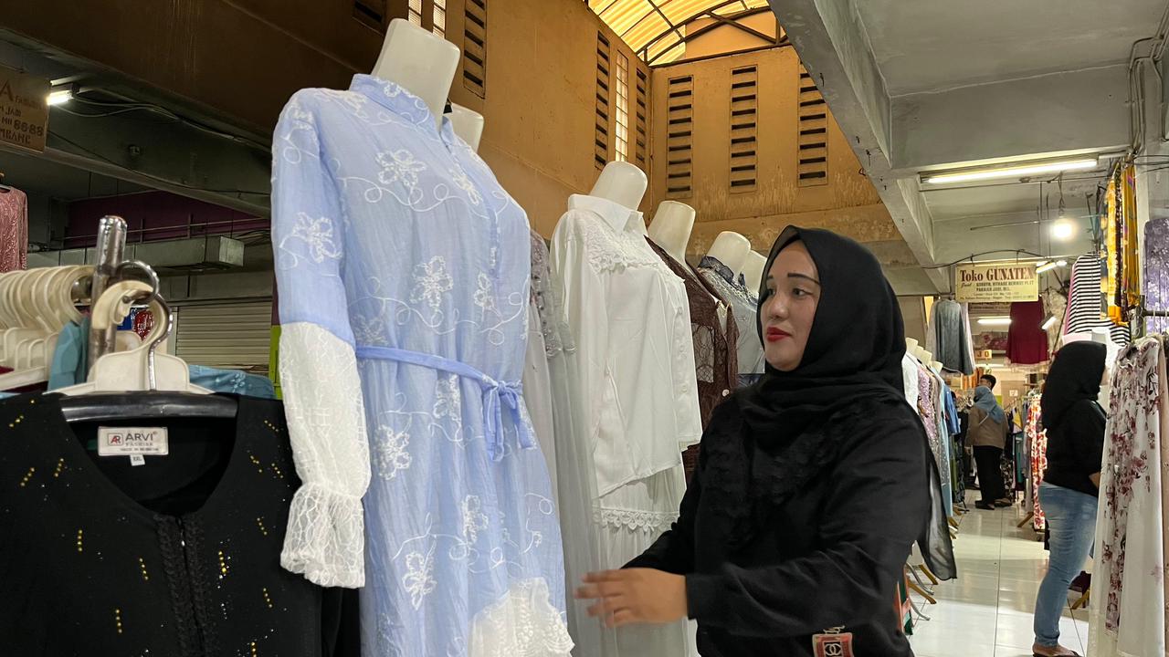 Ria, pedagang baju di Pasar Anyar, Kota Bogor, yang tengah menawarkan gamis model Bini Orang yang lagi tren.