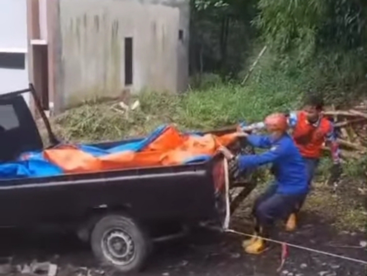 Petugas mengevakuasi sebuah mobil yang mengalami slip.