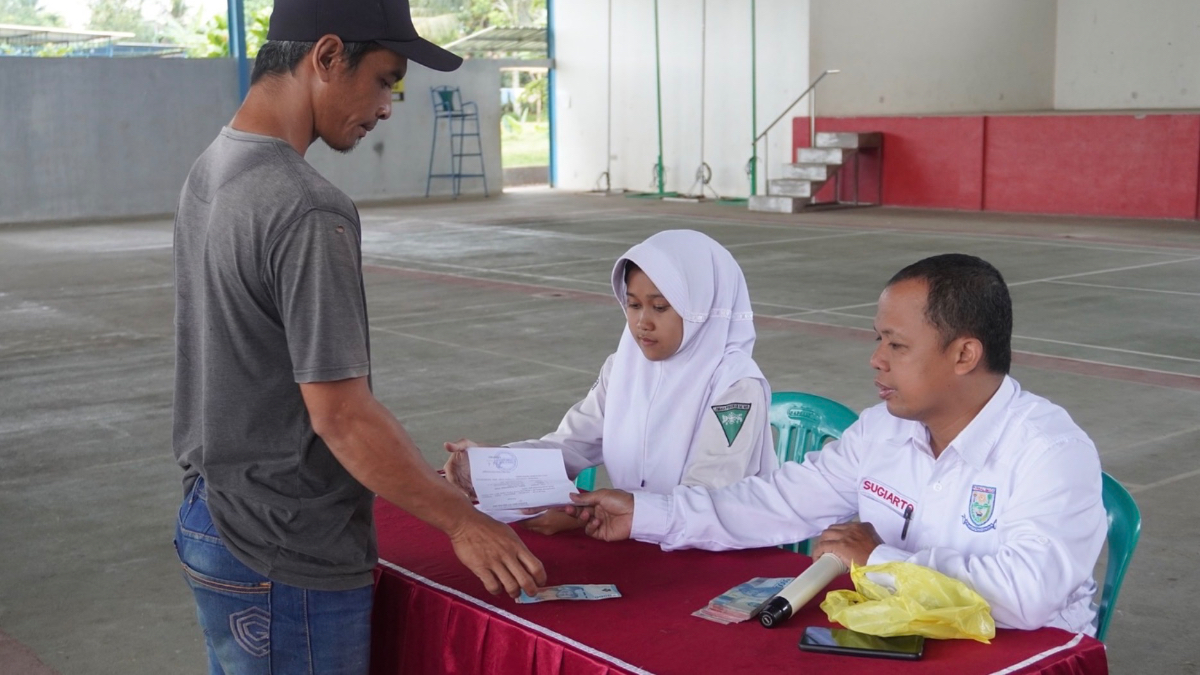 Ilustrasi petugas menyalurkan bansos kepada KPM.