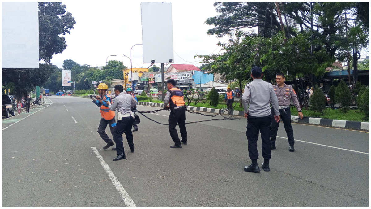 Petugas Rescue DPKP Kota Bogor bersama instansi terkait mengevakuasi kabel PLN yang menjuntai di Jalan Durian, Baranangsiang.
