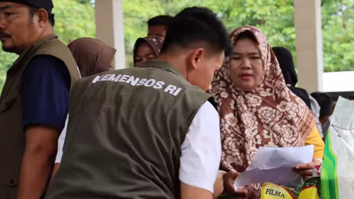 Ilustrasi petugas menyalurkan bantuan sosial atau bansos kepada KPM.