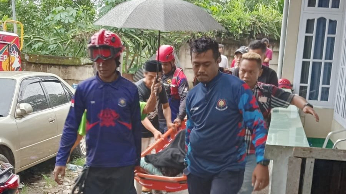 Petugas Damkar Kota Bogor saat mengevakuasi warga Harjasari yang ditemukan terkapar di atas genting.