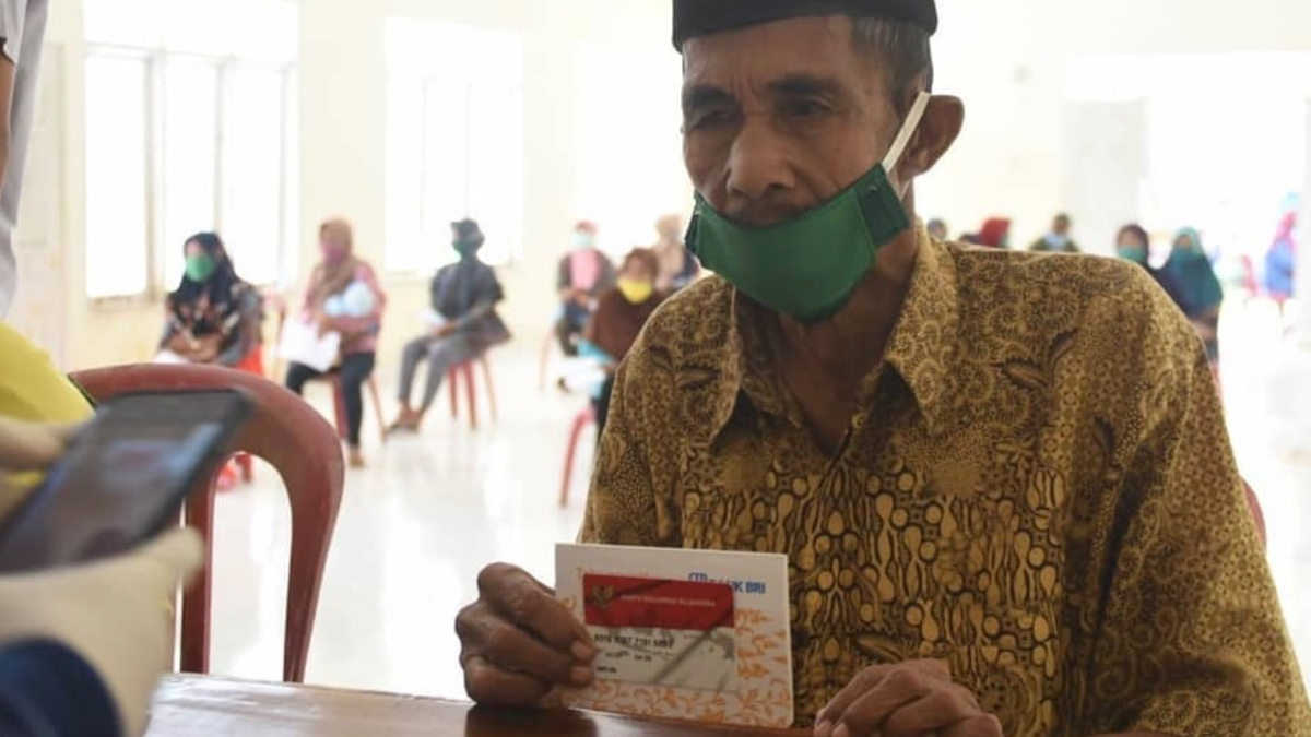 Ilustrasi KPM bansos reguler sedang mencairkan dana bantuan.