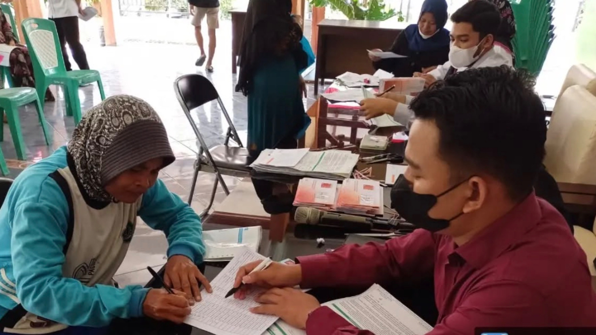 Ilustrasi petugas menyalurkan bansos kepada KPM.