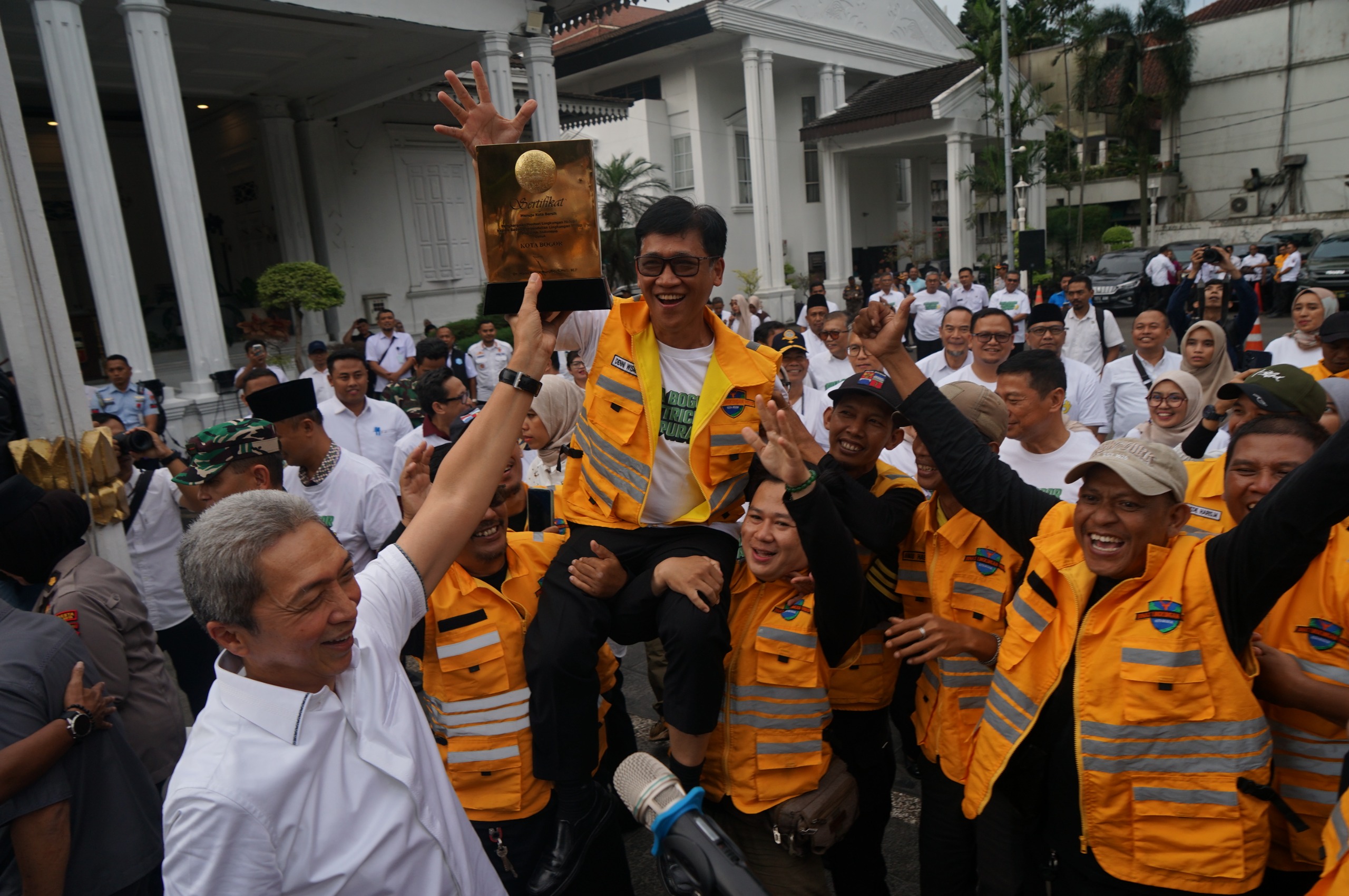 Wali Kota Bogor Dedie A Rachim bersama Kadis DLH Deni Wismanto dan pasukan kuning mengangkat tropy penghargaan bogor menuju kota bersih. 