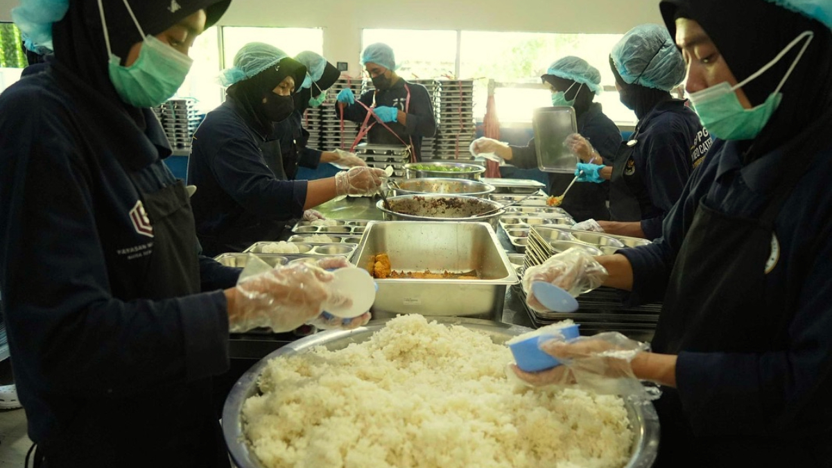 Petugas sedang memasak MBG.