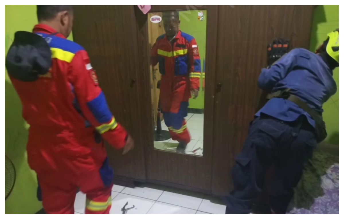 Petugas Damkar Kota Bogor mengevakuasi kucing liar agresif yang terjebak di bawah lemari di kawasan Villa Bogor Indah 3. 