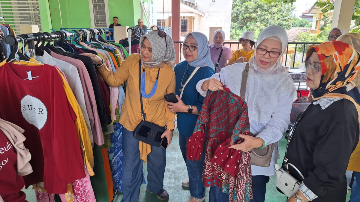 Warga memilih pakaian layak pakai dalam Bazar Ramadhan yang digelar Grup Angklung Srikandi Bogor di Balai Warga RW 08 Komplek Bogor Baru, Bogor Utara, Minggu, 1 Maret 2026.