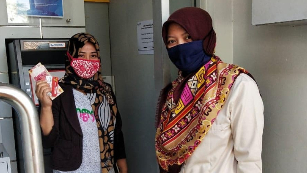 Ilustrasi KPM mencairkan saldo bansos di mesin ATM.
