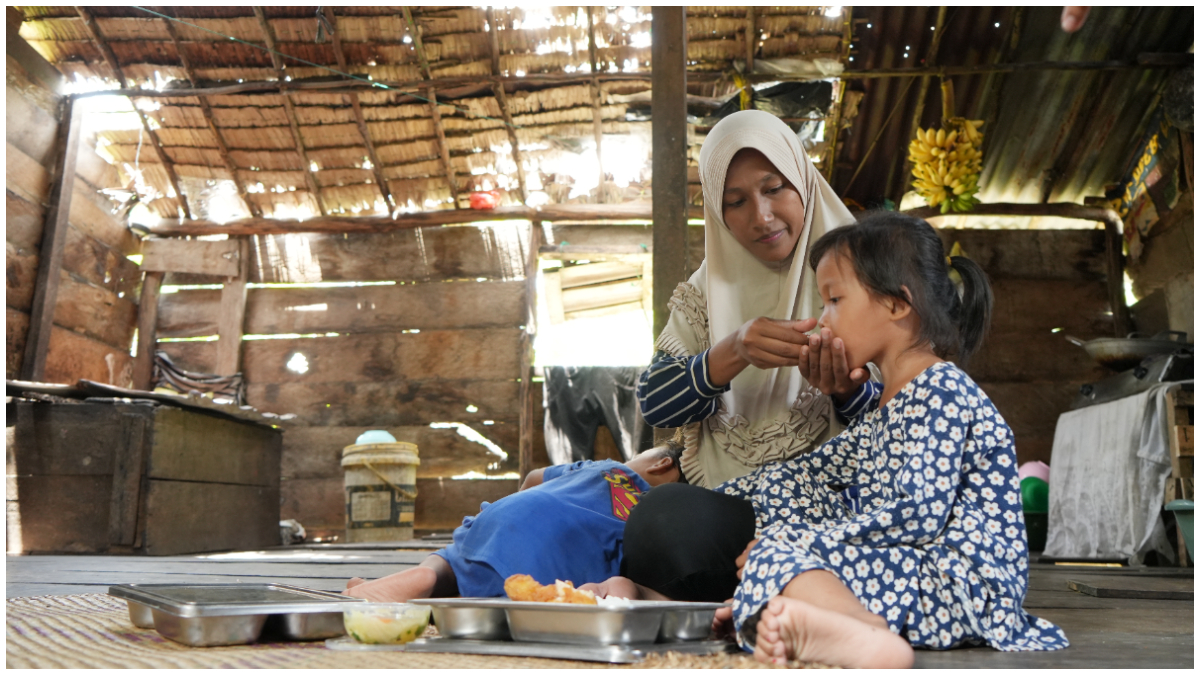 Merianti, ibu di kawasan Lebak Permai, Kayu Agung, Kabupaten&nbsp;Ogan Komering Ilir,&nbsp;Sumatera Selatan tengah menyuapi anaknya dari Makan Bergizi Gratis