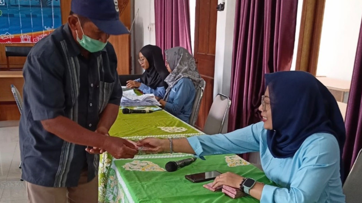 Ilustrasi petugas memberikan dana bansos kepada KPM.