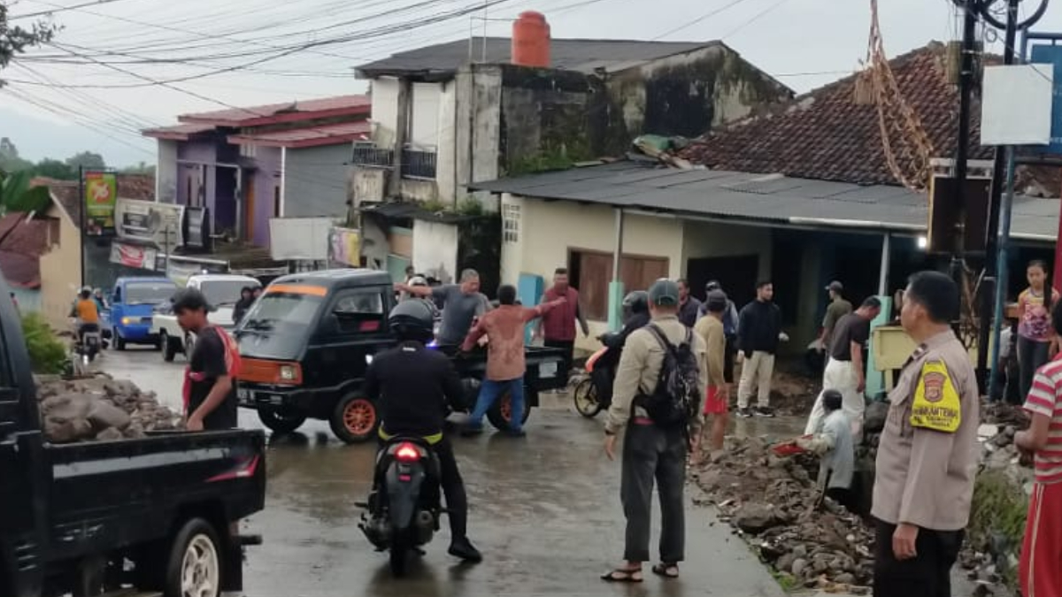 Anggota Polsek Tamansari bersama Satpol PP menangani arus lalu lintas pasca banjir lintasan di Jalan Calobak, Tamansari, Kabupaten Bogor.