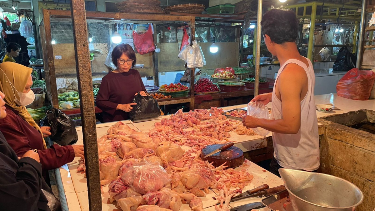 Pedagang daging ayam di Pasar Cibinong, Kabupaten Bogor saat melayani pembeli.
