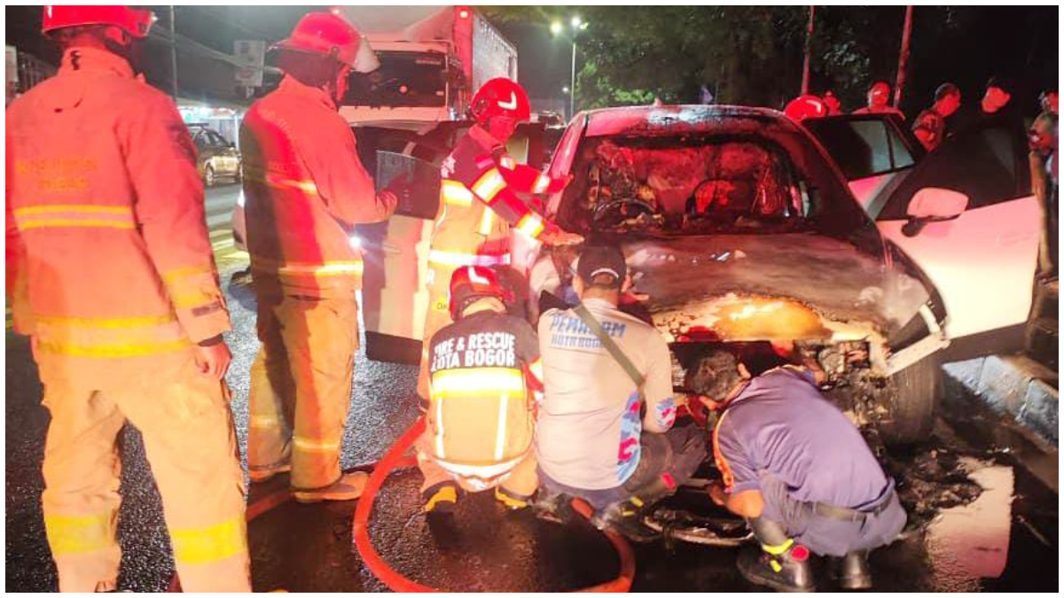 Petugas Damkar Kabupaten Bogor saat membantu memadamkan api yang membakar mobil di Jalan Raya Jakarta - Bogor.