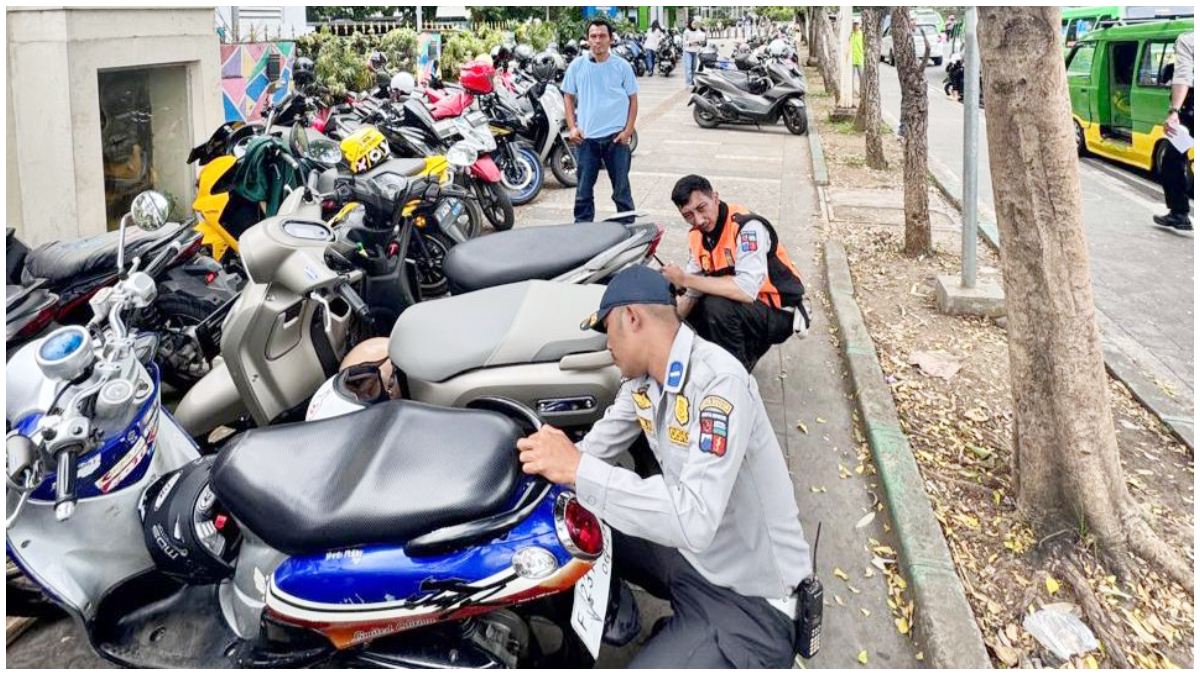 Petugas Dishub saat menggembosi roda kendaraan yang parkir liar.