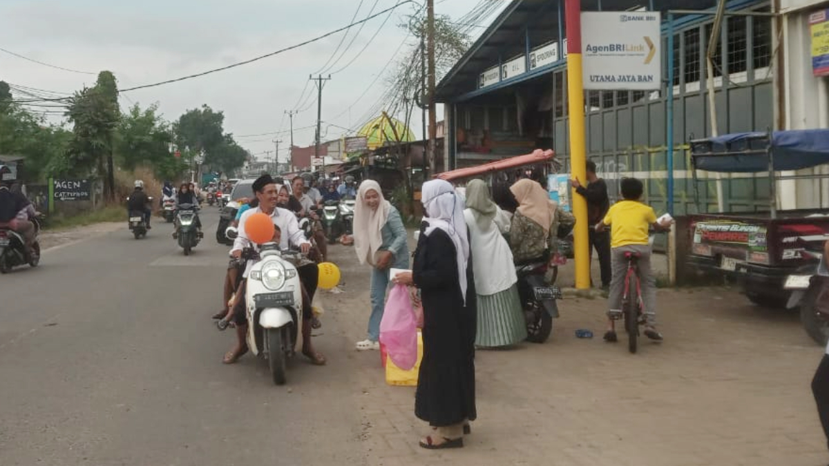 Ibu-ibu yang tergabung dalam Kader Posyandu Salak, Desa Sukamulya, Kecamatan Rumpin Kabupaten Bogor membagikan takjil kepada pengendara yang melintas di Jalan Lapan Cikoleang.