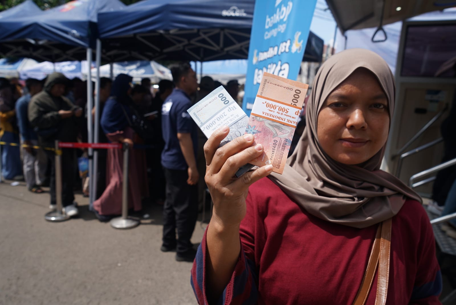 Warga memperlihatkan lembaran uang baru yang didapatnya dari mobil penukaran uang di acara  Bogor Ramadan Fest dihalaman perpustakaan daerah Kota Bogor, Ju'mat 13 Maret 2026.