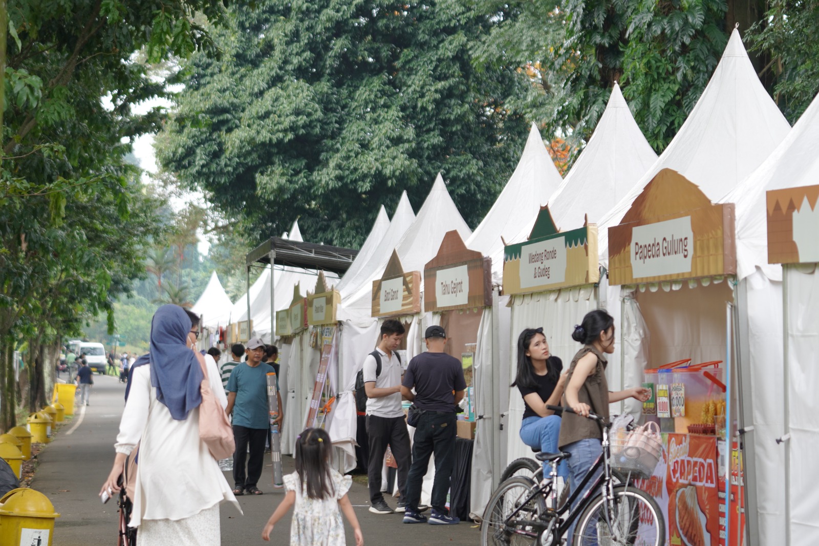 Pengunjung menikmati rangkaian program Poelang Kampeong di Kebun Raya Bogor yang menghadirkan nuansa kampung halaman melalui kuliner, pertunjukan budaya, hingga permainan tradisional.