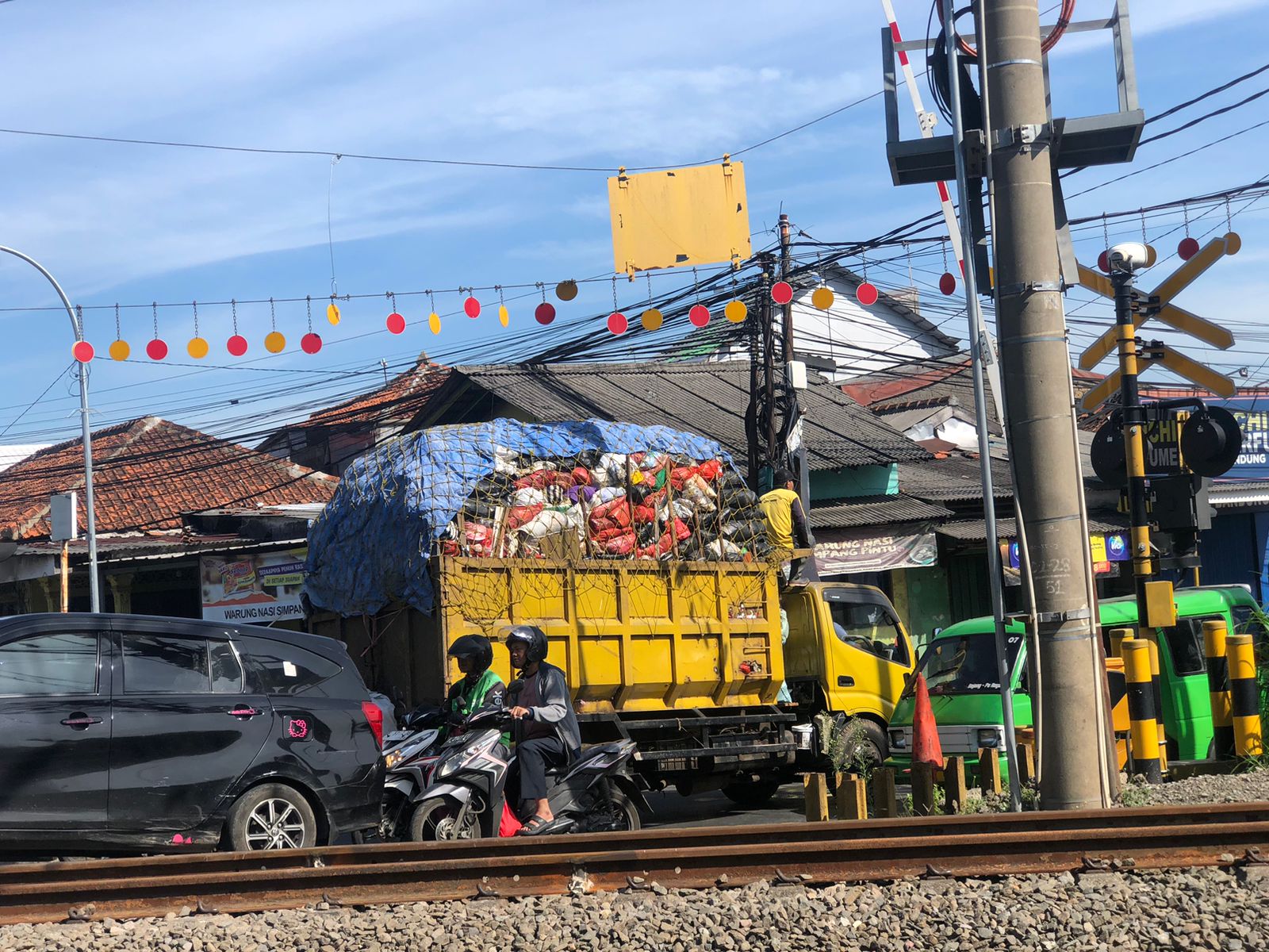 Truk DLH yang tengah membawa sampah dan melintas di perlintasan kereta Kebon Pedes.
