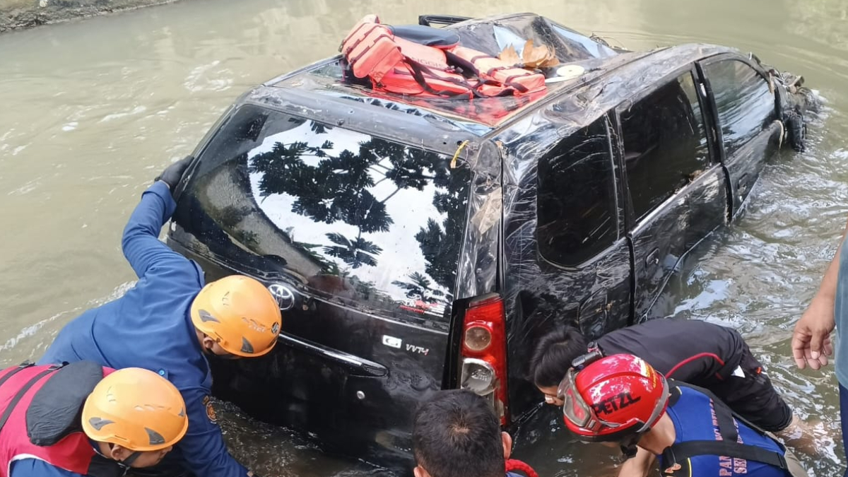 Petugas Damkat Kota Depok melakukan evakuasi mobil yang terseret banjir, Senin, 23 Maret 2026.