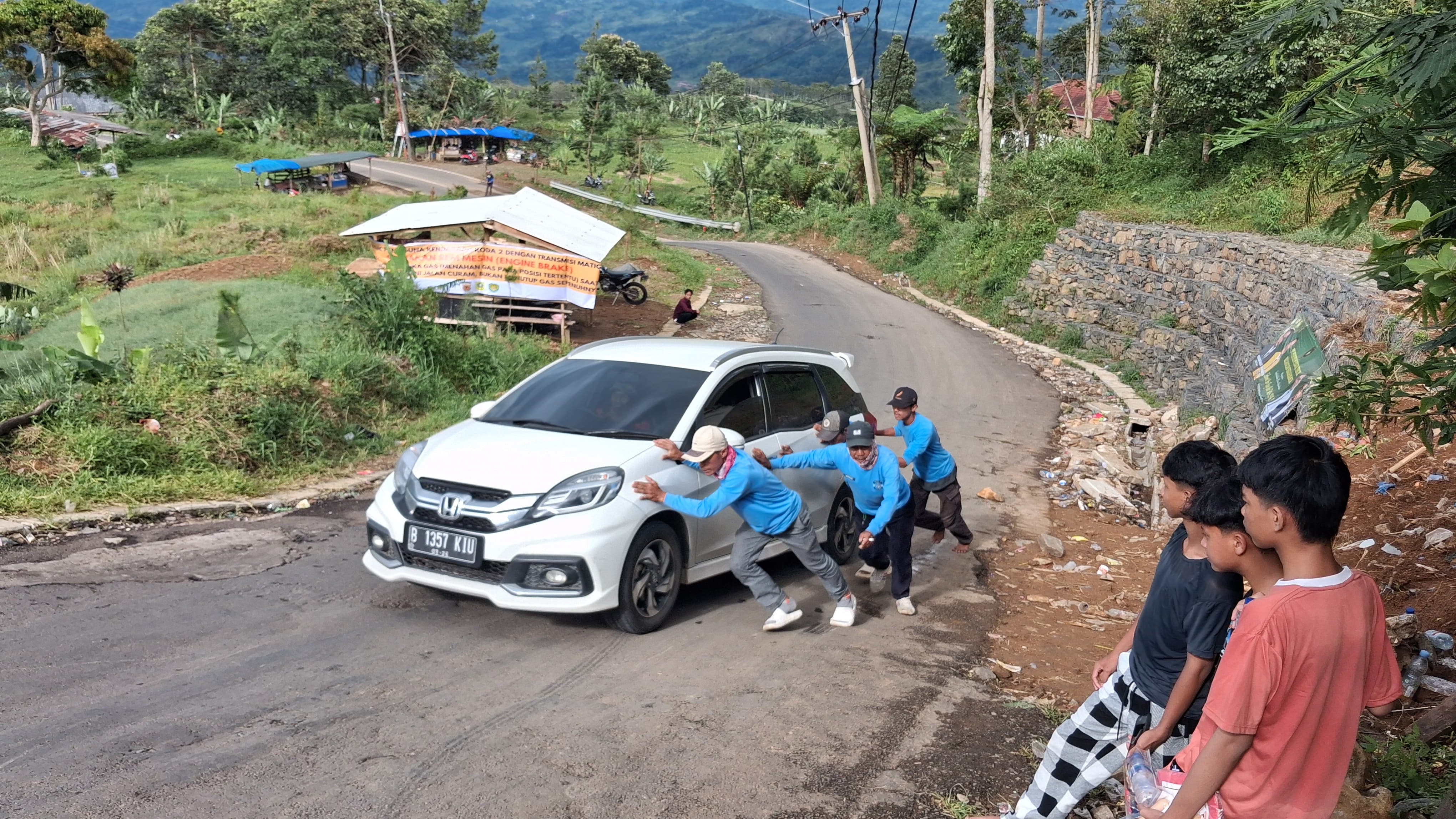 Relawan tanjakan 2000 saat membantu pengendara yang tidak kuat menanjak di kawasan Puncak Dua, Desa Wargajaya, Kecamatan Sukamakmur, Kabupaten Bogor, Rabu, 25 Maret 2026.