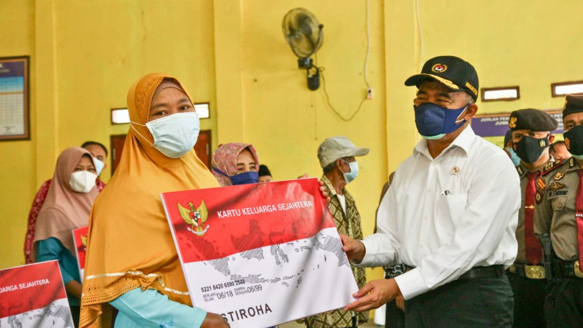 Ilustrasi serah terima KKS bansos antara petugas dan KPM.