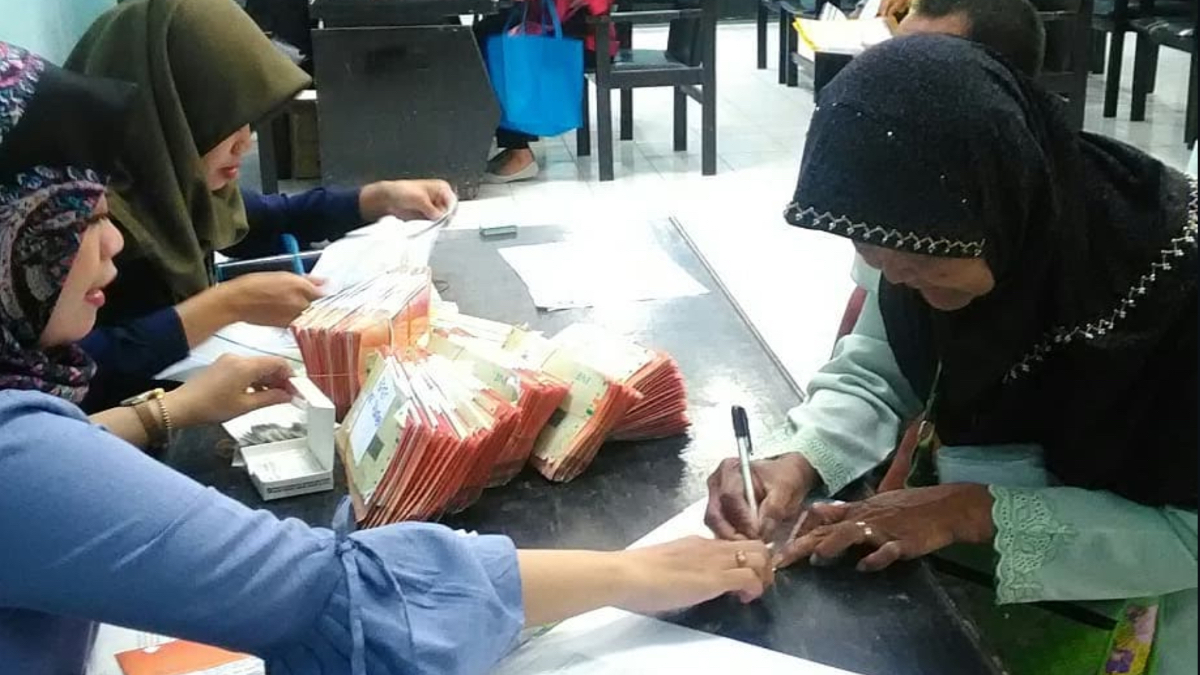 Ilustrasi petugas menyalurkan bansos kepada KPM.