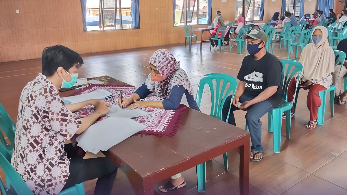 Ilustrasi petugas menyalurkan bansos kepada penerima manfaat.