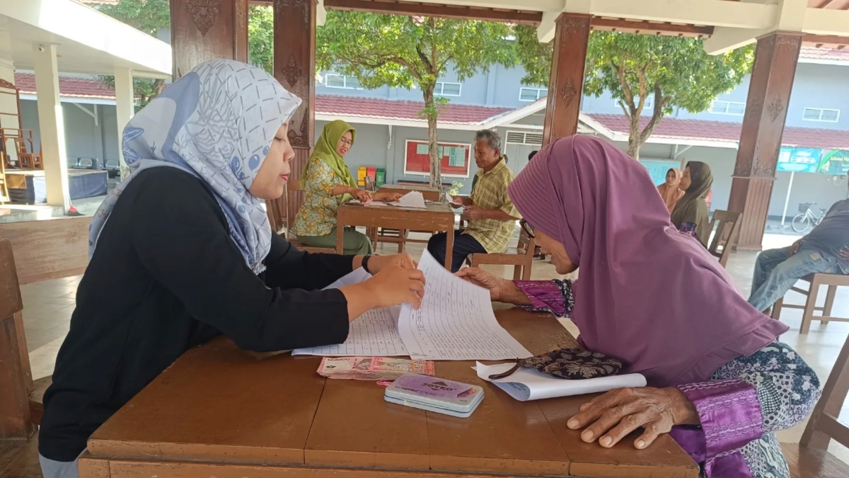 Ilustrasi petugas memberikan bansos kepada KPM.