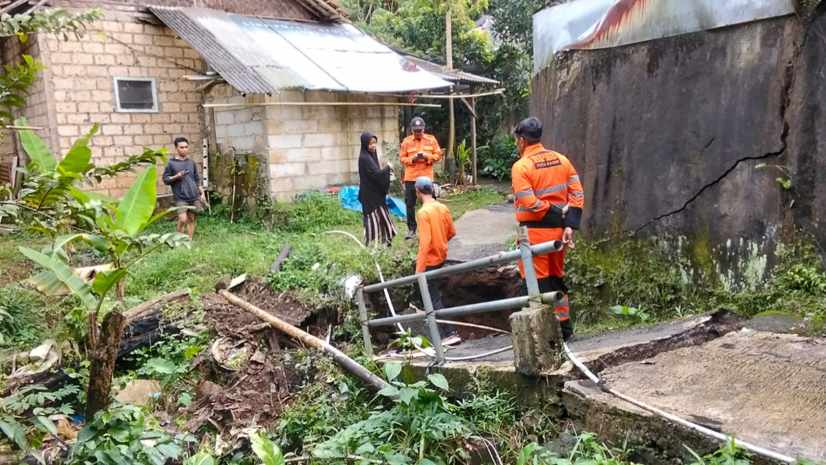 Personel BPBD Kota Bogor saat meninjau jembatan yang amblas di Pamoyanan, Kecamatan Bogor Selatan.