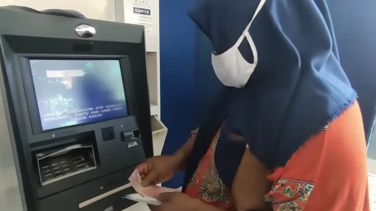 Ilustrasi pencairan bansos reguler melalui mesin ATM. (Foto: Youtube Info Bansos)