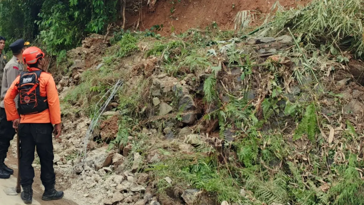 Petugas mengevakuasi material tanah yang menutup jalur utama warga di Kampung Lewibatu, RT 01/01, Sabtu 4 April 2026.  (Nasir/ Radar Bogor)