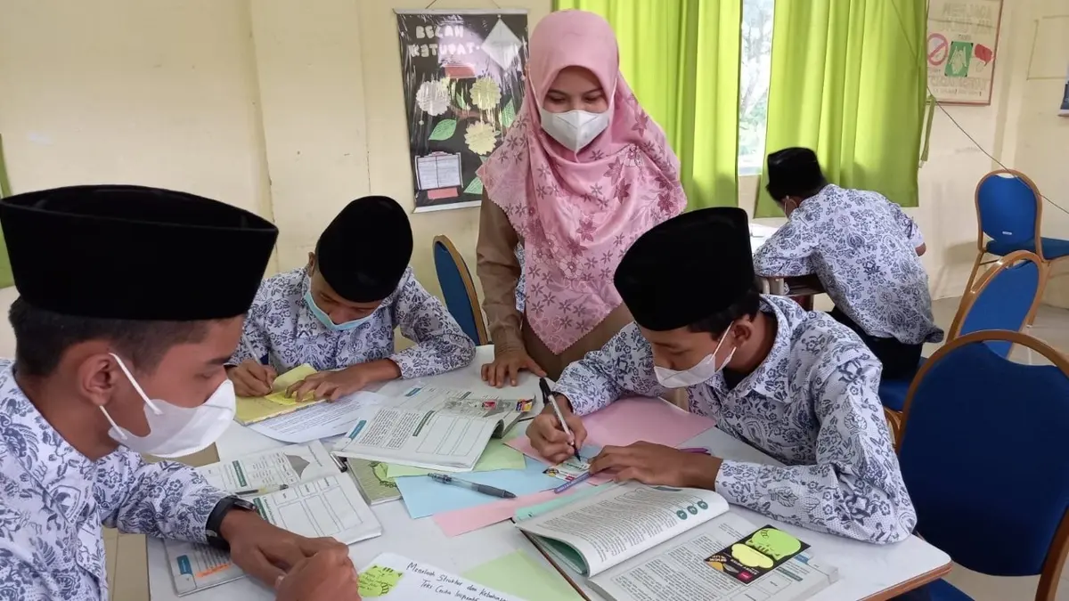 Ilustrasi guru membimbing siswa belajar di dalam kelas. (Foto: smpnmadanipekanbaru.sch.id)