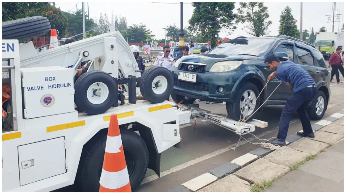 Petugas Dishub saat menindak kendaraan mobil yang melanggar parkir liar di bahu jalan Lingkar Pakansari. (Foto : Hendi Novian/Radar Bogor)