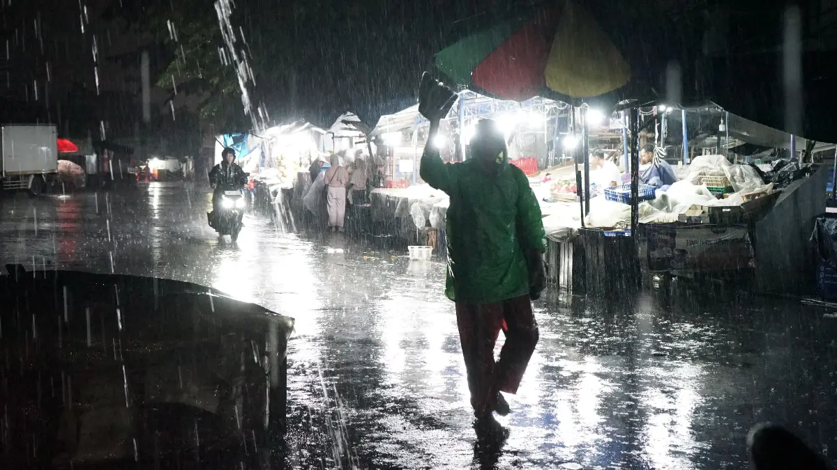 Aktivitas warga tetap berlangsung di tengah hujan deras yang melanda Kota Bogor sejak sore hingga malam, Minggu, 19 April 2026 (Aziz/Radar Bogor)